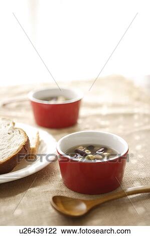 Stock Image - Plate of rye bread and bowls of bean soup. Fotosearch