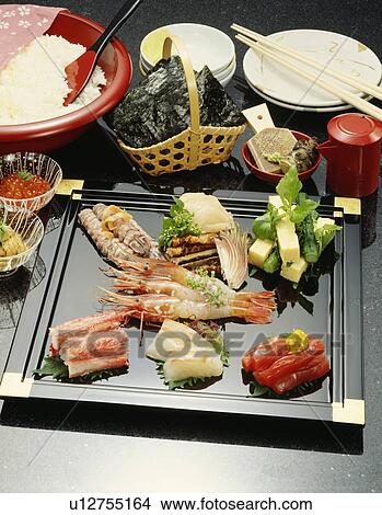 Picture - Plate of sliced fish, black background. Fotosearch