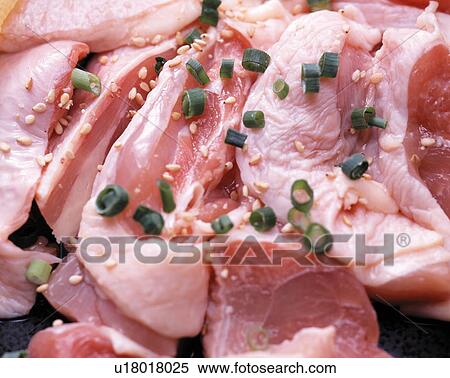 Stock Photography - Raw chicken garnished with spring onion and sesame seeds. Fotosearch