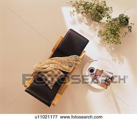 Stock Photo - Reclining chair and coffee table with pot plants. Fotosearch