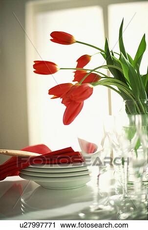 Stock Image - Red napkins and tulips with white tableware. Fotosearch