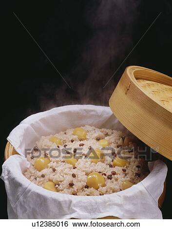 Stock Photograph - Red rice cooked with chestnuts, black background. Fotosearch