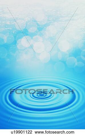 Stock Image - Rippled water surface with lens flare. Fotosearch