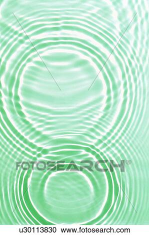 Stock Image - Rippled water with green background. Fotosearch