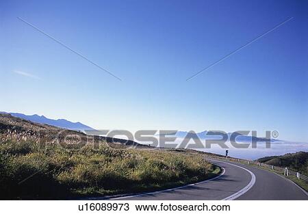 Stock Image - Road beside a sea of cloud on Mt. Kuruma plateau. Nagano Prefecture, Japan. Fotosearch