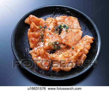 Stock Photograph - Roast meat on a plate garnished with spring onion and sesame seeds. Fotosearch