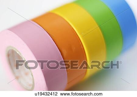 Stock Image - Rolls of colorful adhesive tape, close up, white background. Fotosearch