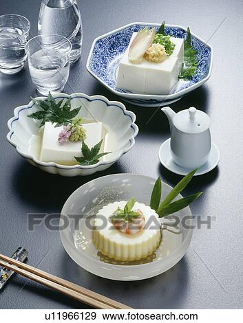 Stock Photo - Sake and bowls of bean curds, black background. Fotosearch