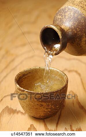 Sake pouring into Sake cup, close up View Large Photo Image Stock Image - Sake pouring into Sake cup, close up. Fotosearch