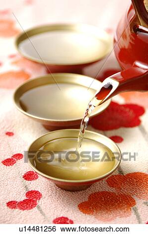 Sake pouring into Sake cups, close up View Large Photo Image Stock Photograph - Sake pouring into Sake cups, close up. Fotosearch
