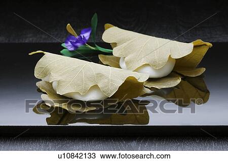 Stock Image - shi wrapped in leaves, black background. Fotosearch