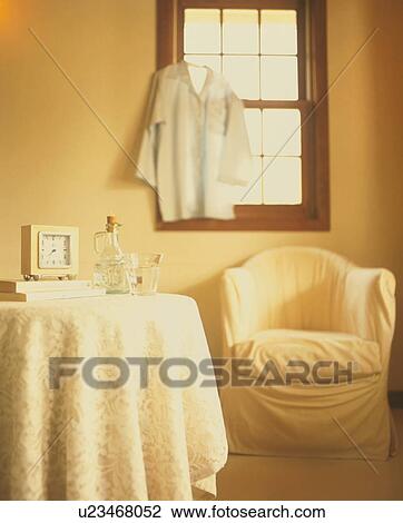 Shirt hanging on window in room with chair and table View Large Photo Image Stock Image - Shirt hanging on window in room with chair and table. Fotosearch