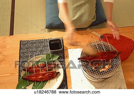 Skewered fish being cooked on charcoal brazier View Large Photo Image Stock Photo - Skewered fish being cooked on charcoal brazier. Fotosearch