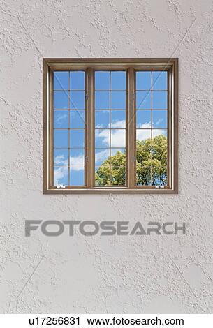 Stock Image - Sky view through window in white textured wall. Fotosearch