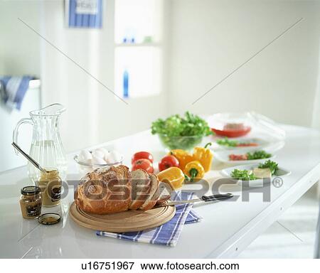Stock Photo - Sliced bread, mustard and vegetables on kitchen counter. Fotosearch