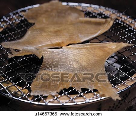 Stock Photography - Slices of dried fish on grill, close up. Fotosearch