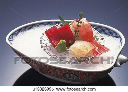 Stock Photography - Slices of raw fish on crushed ice, black background. Fotosearch