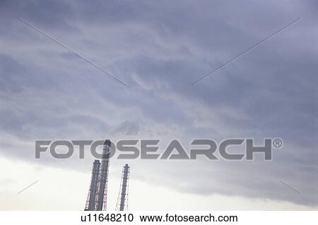 Stock Image - Smokestacks under a Cloudy Sky. Kurihama, Kanagawa Prefecture, Japan. Fotosearch