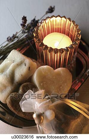 Stock Photograph - Soap and burning candle, white background. Fotosearch