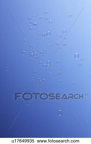 Stock Photography - Soap bubbles in sky, blue background. Fotosearch