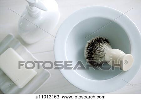 Stock Image - Soap in a dish, hand soap dispenser and shaving brush. Fotosearch