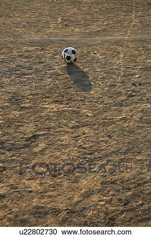 Stock Image - Soccer ball on ground. Fotosearch
