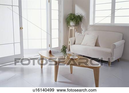 Stock Photo - Sofa and coffee table in room with glass doors. Fotosearch