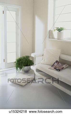 Stock Photo - Sofa in white room with cushion on floor. Fotosearch