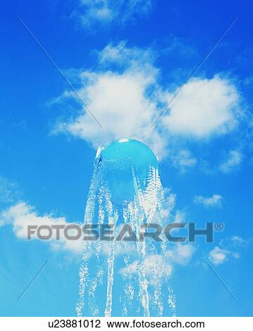 Stock Image - Sphere and water rising in sky. Fotosearch