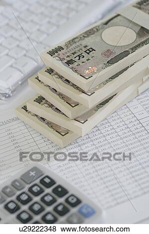Stock Photo - Stack of Japanese money and calculator. Fotosearch