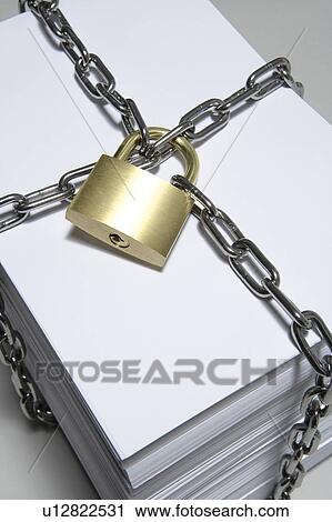 Stock Image - Stack of papers wrapped in chain, close up, white background. Fotosearch