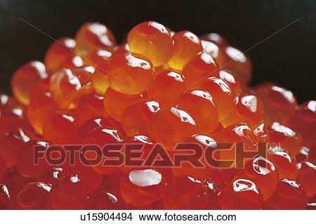 Picture - Stack of salmon roe, close up, black background. Fotosearch