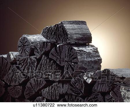 Stock Image - Stack of sticks of coal, close up, colored background. Fotosearch