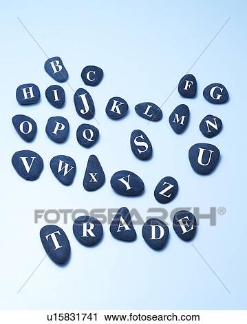 Stock Image - Stones with alphabets, spelling TRADE, blue background. Fotosearch