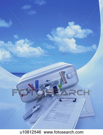 Stock Photograph - Suitcase and paperwork in front of a blue sky. Fotosearch