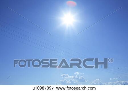 Stock Photo - Sun and power lines in blue sky, blue background. Fotosearch