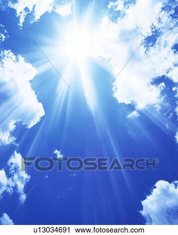Stock Image - Sun, blue sky and clouds. Fotosearch