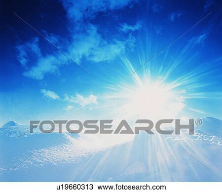 Stock Image - Sun shining brightly over snow. Fotosearch