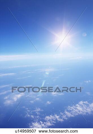 Stock Photo - Sun shining in blue sky. Fotosearch