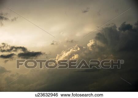 Stock Photograph - Sunlight Shining on Dark Clouds. Fotosearch
