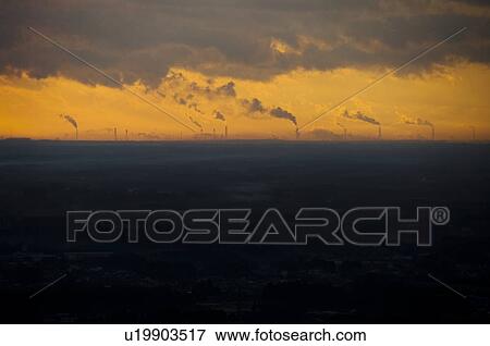 Stock Photo - Sunrise over smoke stacks emitting smoke, Atago-yama, Kasama, Ibaraki Prefecture, Japan. Fotosearch