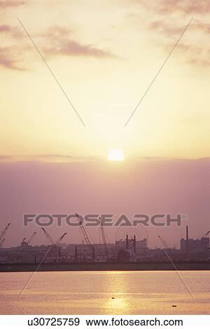 Stock Photo - Sunrise over Tokyo Bay and Industrial Area. Koto-ku, Tokyo, Japan. Fotosearch