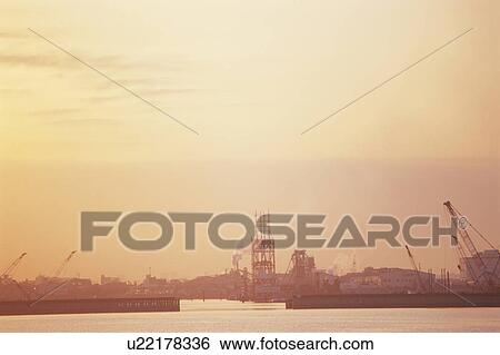 Stock Photograph - Sunrise over Tokyo Bay and Industrial Area. Koto-ku, Tokyo, Japan. Fotosearch