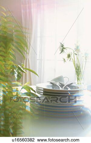 Stock Image - Tableware stacked in the sunlight. Fotosearch
