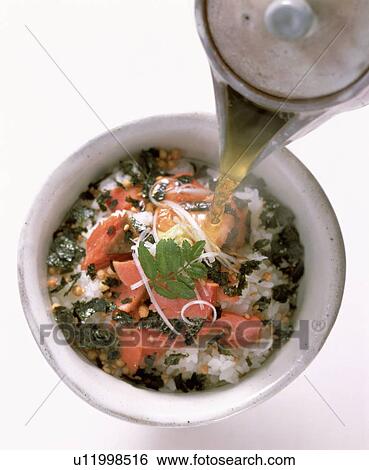 Stock Photograph - Tea being poured onto rice dish. Fotosearch