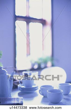 Teapot and cups on table near window View Large Photo Image Stock Photo - Teapot and cups on table near window. Fotosearch