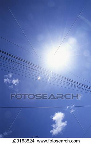 Picture - Telephone lines against blue sky with clouds. Fotosearch