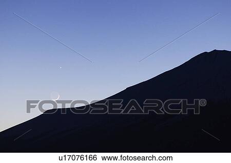 Stock Photograph - The Moon and Venus over Mt. Fuji at dusk. Masuho, Yamanashi Prefecture, Japan. Fotosearch