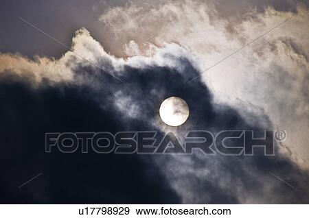 The Sun Appearing Behind Dark Clouds View Large Photo Image Stock Photo - The Sun Appearing Behind Dark Clouds. Fotosearch