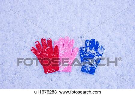 Stock Image - Three Mittens Lying on the Snow. Fotosearch